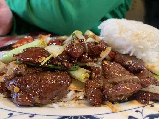 Mongolian Beef with steamed rice — tender sliced beef sautéed in savory sauce